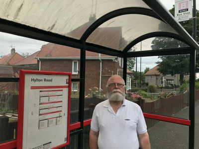 Councillor George Smith at a bus stop on Hylton Road